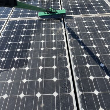 Verschmutzte Solarmodule werden mit einer Bürste und Teleskopstange gründlich gereinigt.