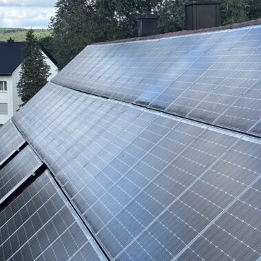 Großflächige Photovoltaikanlage auf einem Hausdach mit deutlich sichtbaren Verschmutzungen auf den Solarmodulen.